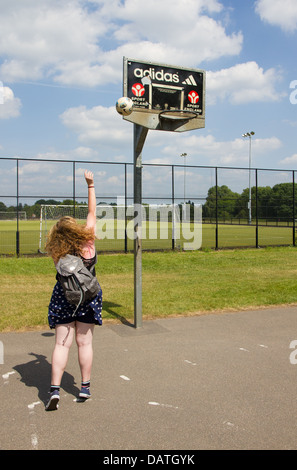 Teenage girl playing netball dans le parc Banque D'Images