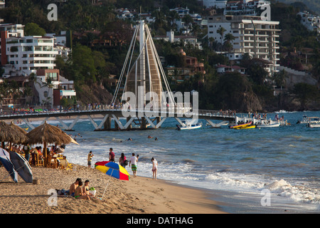 Les touristes vous détendre sur Playa Los Muertos à Puerto Vallarta, au Mexique. Dans l'arrière-plan est l'achèvement récent de la station. Banque D'Images