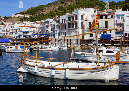 Beau bateau traditionnel catalan à quai avec le Mediterranean village de Puerto de la Selva en arrière-plan, Costa Brava, Espagne Banque D'Images