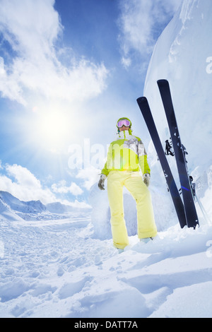 Les jeunes skieurs heureux femme debout avec ski par d'énormes snowdrift Banque D'Images