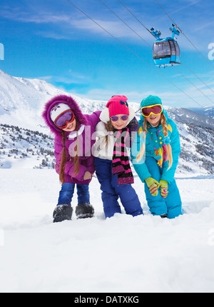 Trois jolies filles snowboarders dans la montagne avec ascenseur de ski de fond sur Banque D'Images