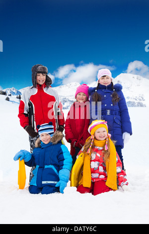 Groupe de cinq amis enfants garçons et filles debout ensemble en dehors dans la neige Banque D'Images