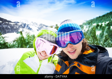 Jeune couple de skieurs avec des montagnes en arrière-plan Banque D'Images