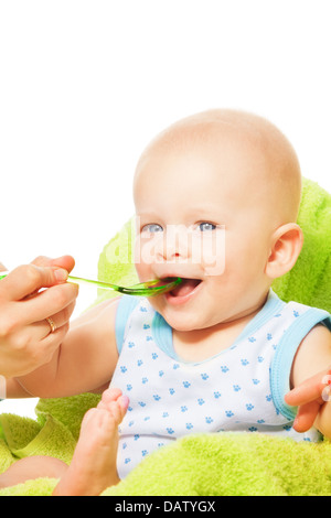 Mignon petit garçon mange de la cuillère avec les mères de l'aide Banque D'Images