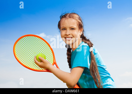 Belle brunet 10 ans petite fille avec raquette de tennis Banque D'Images