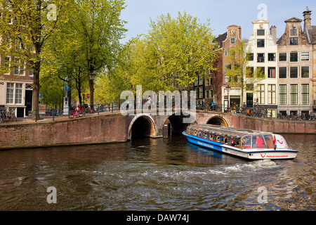 La ville pittoresque d'Amsterdam au printemps avec World of TUI bateau sur un canal cruise, Pays-Bas, Hollande du Nord de la province. Banque D'Images