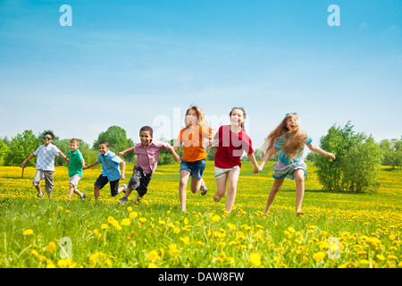 Groupe des sept courir dans le parc les enfants, garçons et filles, de race blanche et noire Banque D'Images