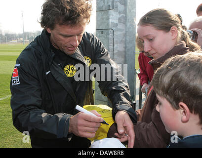 Thomas Doll (L), nouveau signé entraîneur de Bundesliga club BVB Borussia Dortmund, signe des autographes à Dortmund, en Allemagne, le mardi, 13 mars 2007. L'ancien entraîneur en chef de l'Hambourg SV Juergen réussit poupée qui fait face à Romain Paquette six défaites consécutives et causé des fans en colère lui faisant démissionner après seulement dix semaines. Photo : Achim Scheidemann Banque D'Images