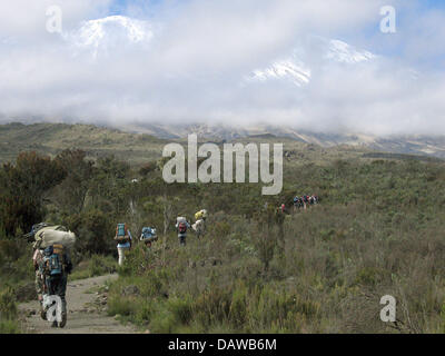 Un groupe de transporteurs transporte les bagages des touristes jusqu'aux pistes du mont Kilimanjaro en Tanzanie, 4 février 2007. Environ 20,000 personnes tentent d'escalader le mont Kilimandjaro chaque année, le seul près de 6.000m de haut grimpable sommet sans cordes et crampon. Photo : Ulrike Koltermann Banque D'Images