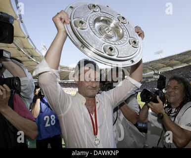 Le VfB Stuttgart l'entraîneur Armin Veh soutient le trophée du championnat de Bundesliga entouré par les photographes sur le terrain au stade Gottlieb-Daimler-à Stuttgart, Allemagne, 19 mai 2007. Stuttgart est le nouveau champion de football. Photo : Ronald Wittek Banque D'Images