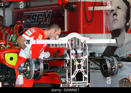 Un mécanicien de la Scuderia Ferrari vérifie à l'avant la suspension d'une voiture de course à Monte Carlo, 23 mai 2007. Le 2007 Fromula 1 Grand Prix de Monaco aura lieu le 27 mai 2007. Photo : JENS BUETTNER Banque D'Images