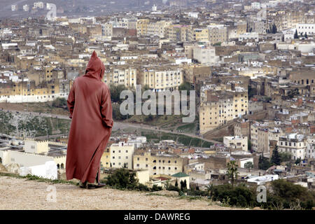 Un homme portant une Djellabiah se dresse sur une colline et regarde vers le bas sur la vieille ville (médina) de ville royale marocaine Fes, 29 mars 2007. Photo : Marijan Murat Banque D'Images