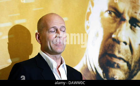 L'acteur américain Bruce Willis pose à la photo pour la prochaine première de son nouveau film "tirb langsam 4.0' ('Live Free or Die Hard') en face d'une affiche du film lui-même à Berlin, 18 juin 2007. Langsam tirb '4.0' sera affiché dans les salles allemandes du 27 juin 2007. Photo : Johannes Eisele Banque D'Images