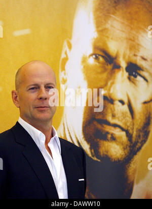 L'acteur américain Bruce Willis pose à la photo pour la prochaine première de son nouveau film "tirb langsam 4.0' ('Live Free or Die Hard') en face d'une affiche du film lui-même à Berlin, 18 juin 2007. Langsam tirb '4.0' sera affiché dans les salles allemandes du 27 juin 2007. Photo : Johannes Eisele Banque D'Images