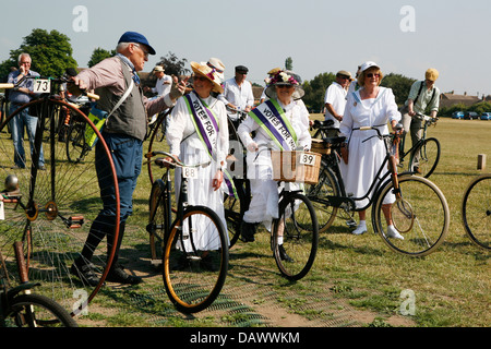 Les gens dans la période des tenues et vélos vintage, les femmes sont vêtues comme les suffragettes. Banque D'Images