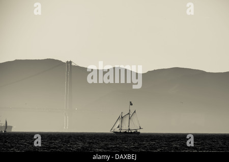 Image Monochrome de deux mâts goélette s'approche du pont Golden Gate dans la brume Banque D'Images