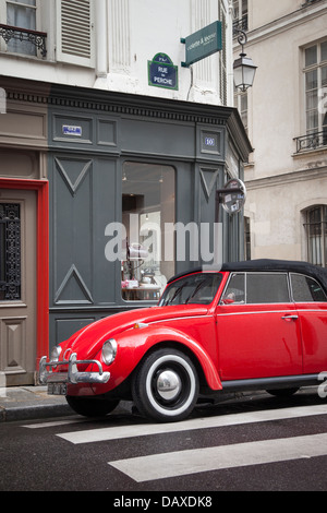 Volkswagen Beetle rouge garée en face de l'expédition boutique dans le Marais, Paris France Banque D'Images
