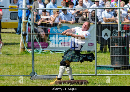Homme portant un kilt écossais lance un marteau au Highland Games event Banque D'Images
