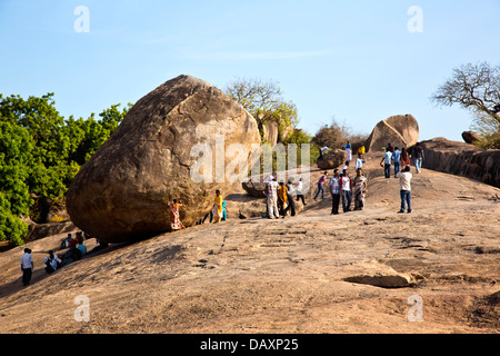 Les touristes près d'un rocher sur une colline, Krishna's Butter Ball, Mahabalipuram, district de Kanchipuram, au Tamil Nadu, Inde Banque D'Images