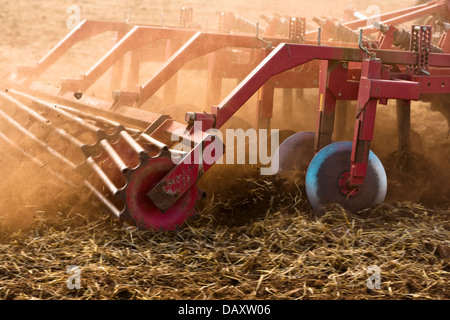 Tracteur charrue tirée de cultiver un champ. Flou sur les pièces en rotation et sur le terrain. Banque D'Images