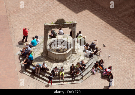 Vue aérienne personnes assises autour de puits Piazza della Cisterna San Gimignano Toscane Italie Banque D'Images