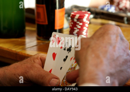 L'homme regarde ses cartes au cours d'une partie de poker. Se concentrer sur les cartes Banque D'Images
