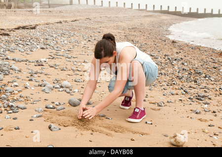 Jeune femme sur une plage de sable des animaux Banque D'Images