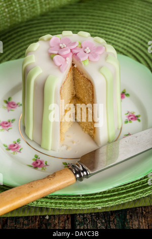 Décoration de luxe mini gateau avec des pétales de rose sur fond vert. Banque D'Images