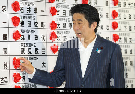 Tokyo, Japon. 21 juillet, 2013. Le Premier ministre japonais Shinzo Abe sourire alors qu'il met une rosette sur un nom de Parti libéral-démocrate à l'égard du lauréat au cours de la chambre haute à l'administration centrale des élections LDP le 21 juillet 2013 à Tokyo, Japon. Koichi Kamoshida/crédit : Jana Press/ZUMAPRESS.com/Alamy Live News Banque D'Images