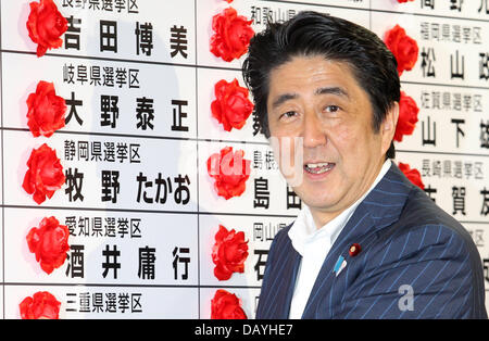 Tokyo, Japon. 21 juillet, 2013. Le Premier ministre japonais Shinzo Abe sourire alors qu'il met une rosette sur un nom de Parti libéral-démocrate à l'égard du lauréat au cours de la chambre haute à l'administration centrale des élections LDP le 21 juillet 2013 à Tokyo, Japon. Koichi Kamoshida/crédit : Jana Press/ZUMAPRESS.com/Alamy Live News Banque D'Images