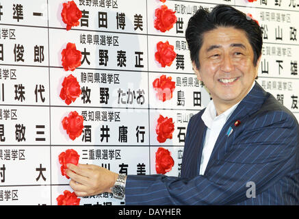 Tokyo, Japon. 21 juillet, 2013. Le Premier ministre japonais Shinzo Abe sourire alors qu'il met une rosette sur un nom de Parti libéral-démocrate à l'égard du lauréat au cours de la chambre haute à l'administration centrale des élections LDP le 21 juillet 2013 à Tokyo, Japon. Koichi Kamoshida/crédit : Jana Press/ZUMAPRESS.com/Alamy Live News Banque D'Images