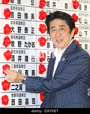 Tokyo, Japon. 21 juillet, 2013. Le Premier ministre japonais Shinzo Abe sourire alors qu'il met une rosette sur un nom de Parti libéral-démocrate à l'égard du lauréat au cours de la chambre haute à l'administration centrale des élections LDP le 21 juillet 2013 à Tokyo, Japon. Koichi Kamoshida/crédit : Jana Press/ZUMAPRESS.com/Alamy Live News Banque D'Images