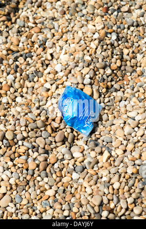 Durex préservatif vide jetés gauche paquet sur plage de galets UK Banque D'Images