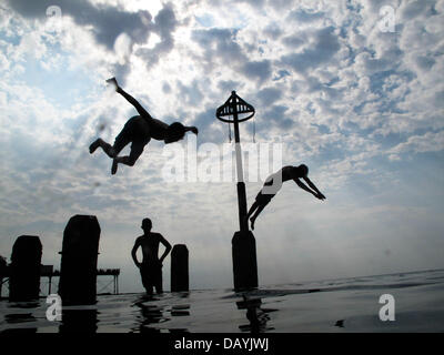 Pays de Galles Aberystwyth UK, 21 juillet 2013. Au moment où le sort de beau temps chaud continue au Royaume-Uni, les adolescents plongée, sauter et nager dans les eaux chaudes et peu profondes au large de la plage d'Aberystwyth, sur la côte de la Baie de Cardigan, West Wales Crédit photo : Keith morris/Alamy Live News Banque D'Images