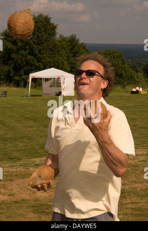 Man juggling coco à Worldham Fête du Village, Hampshire, Royaume-Uni. Dimanche 14 juillet 2013. Banque D'Images