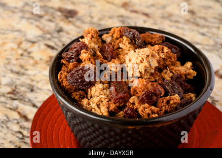 Un petit bol de granola maison rouge sur un plat. Banque D'Images