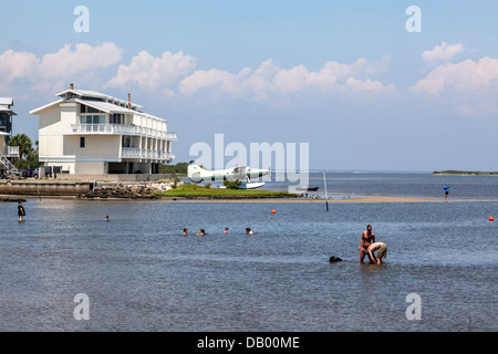 Petite mer avion garé derrière un bâtiment le long de la côte du golfe de Floride à Cedar Key. Baigneurs et piscine chien en premier plan. Banque D'Images