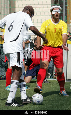 Joueurs de foot aveugle illustré en action pendant le match Allemagne (maillots blancs) contre l'Espagne lors de la 'journée paralympique" en face de la porte de Brandebourg à Berlin, Allemagne, 23 août 2007. L'événement a lieu à peine un an avant les Jeux Paralympiques de Beijing. Photo : Rainer Jensen Banque D'Images