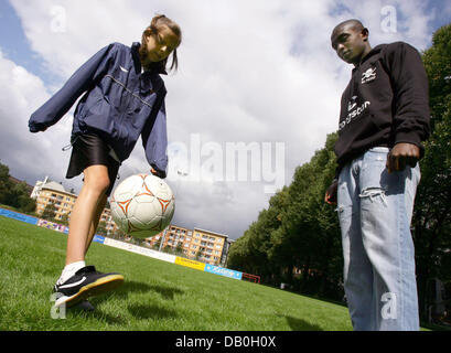 Dix ans Chloe Hegland (L), détenteur du record du monde de vitesse de jonglage football, présente ses compétences en regard de professionnel de soccer Charles Takyi du club de deuxième division de la Bundesliga FC St Pauli à Hambourg, Allemagne, 28 août 2007. Hegland atteint 155 contacts en 30 secondes, 311 en une minute et 40 000 en quatre heures. Sa performance a été d'une valeur d'une entrée dans le Livre Guinness des W Banque D'Images