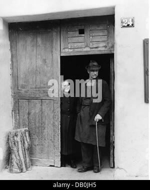 Personnes, couples, couples âgés, couple âgé de Mittenwald debout dans l'entrée de la maison regardant la procession de carnaval sur Fat jeudi, Mittenwald, 1956, droits supplémentaires-Clearences-non disponible Banque D'Images