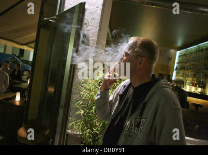 Un fumeur a une fumée à l'extérieur d'un bar plutôt vide à Francfort-sur-Main, Allemagne, 04 octobre 2007. Depuis le 01 octobre 2007, l'interdiction de fumer dans les bars et restaurants est entrée en vigueur dans l'état de Hesse. Photo : Frank Rumpenhorst Banque D'Images