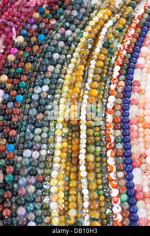 Les chaînes de perles colorées et des colliers sur un étal de marché en Italie, provenant de la province du Punjab, en Inde - mixte, multi-couleur Banque D'Images