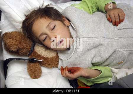 Les neuf ans fille afghane nommé Masuma repose sur le bord d'un avion en direction de Hambourg (Allemagne) de Kaboul, Afghanistan, le 17 octobre 2007. Masuma souffre forment une fracture du col du fémur à la suite d'un accident elle a été impliqué. 59 enfants gravement blessés d'Afghanistan ont été transportés à l'Allemagne d'être pousse dans 30 cliniques à l'échelle nationale. Il est l'un des plus grands ponts aériens humanitaires de l'UE Banque D'Images