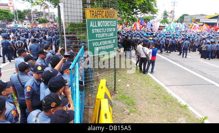 La ville de Quezon, Philippines. 22 juillet, 2013. Des milliers de policiers dans la ville de Quezon ont été dispersés au cours de l'état de la Nation (SONA) du Président Benigno Aquino Jr. pour barricader les différents groupes militants qui sont insatisfaits de la performance du président. Selon les groupes, ils n'ont pas constaté aucune amélioration de la vie des Philippins pour les trois dernières années du président. Sherbien Dacalanio : Crédit/Alamy Live News Banque D'Images