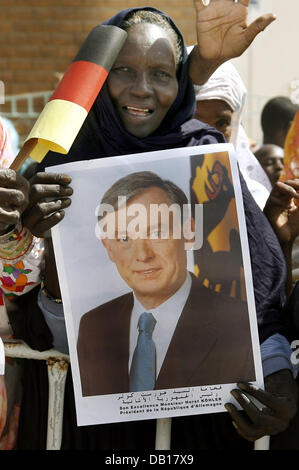 Une femme mauritanienne détient un portrait et un drapeau allemand d'accueillir le président allemand Horst Koehler à Nouakchott, Mauritanie, 14 novembre 2007. Koehler et son épouse Eva sont en visite officielle en Afrique du Nord et se rendra en Algérie, de la Mauritanie et de Malte. Photo : WOLFGANG KUMM Banque D'Images