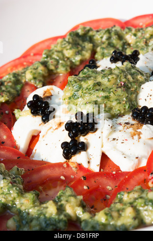 Une salade de tomates, mozzarella de bufflonne, frais au pesto et perles de vinaigre balsamique. Banque D'Images