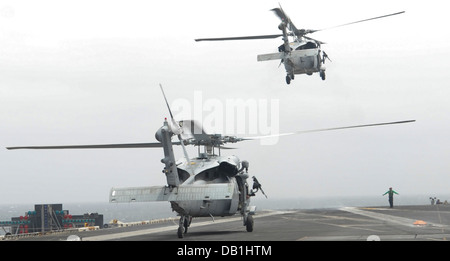 MH-60S Deux hélicoptères Sea Hawk affectés à l'Escadron d'hélicoptères de combat de la mer (HSC) 6 décollera de la cabine de pilotage à bord du porte-avions USS Nimitz (CVN 68). Le groupe aéronaval du Nimitz est déployé sur le 5e Flotte des États-Unis zone de responsabilité condu Banque D'Images