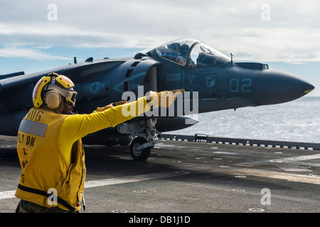 Maître de Manœuvre Aviation 2e classe Eldeen Ebanks signaux pour le pilote d'un Harrier AV-8B qu'il est autorisé à lancer depuis la cabine de pilotage du navire d'assaut amphibie USS Bonhomme Richard (DG 6). Bonhomme Richard participe à l'exercice Talism Banque D'Images