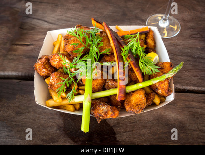Close up of fish and chips avec des carottes, des asperges et une tranche de citron Banque D'Images