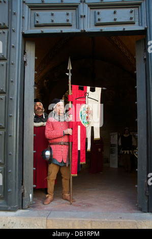 Homme habillé en costume médiéval tenant une bannière Volterra Toscane Italie Banque D'Images